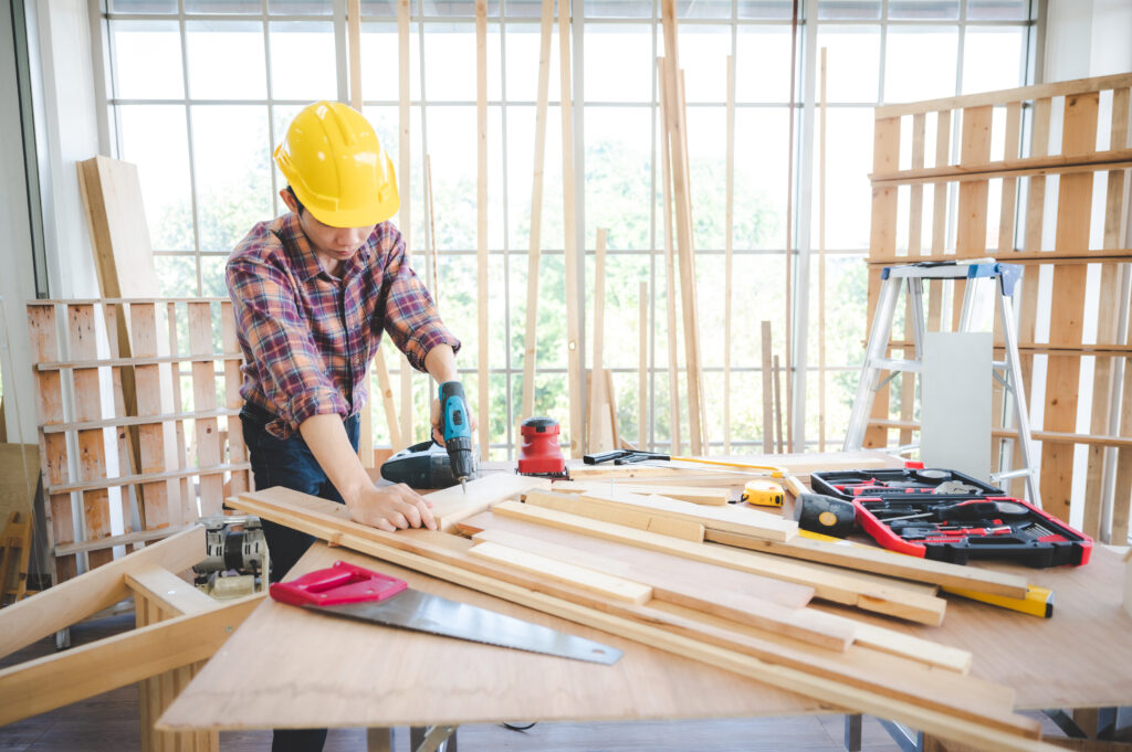 young carpenter Asian man, wooden maker craftsman working with a industry carpentry tool workshop